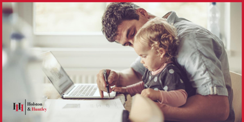 Man holding baby daughter doing finances