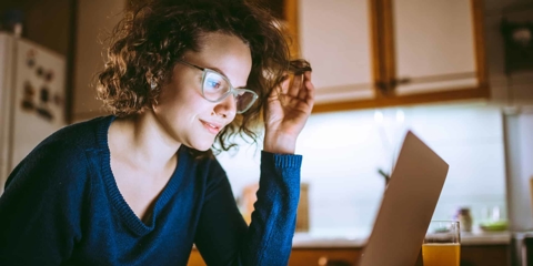 Woman smiling while looking at laptop