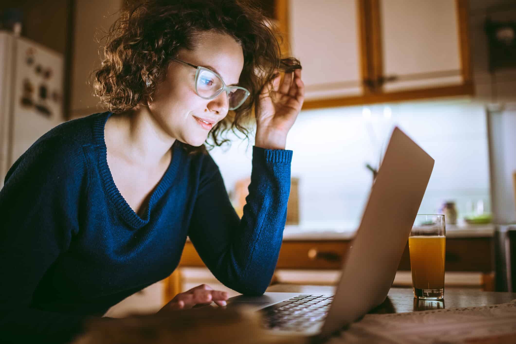Woman smiling while looking at laptop