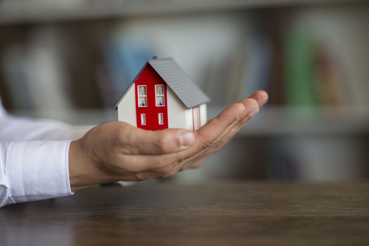 Hands holding a house